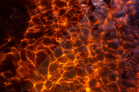 Abstract nature background of real beauty. Ocean bokeh, sea ripples on the surface of waves. Shadow texture of underwater depth bottom sand through water liquid. modern design. red-yellow shadesの写真素材