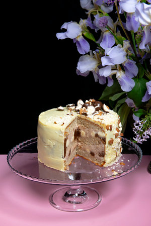 Festive banana cake in white chocolate, decorated with nuts, cookies and chocolate on a bright...