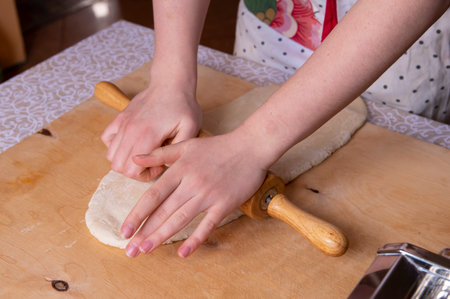 The process of rolling out the dough by a girl at home. Prepares Neapolitan sfogliatella at home, for his family. the concept of cooking gourmet dishes at home. real peopleの写真素材