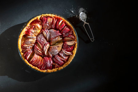 Homemade Apple pies on a Dark background, Top view. The classic autumn dessert for Thanksgiving is organic Apple pie. The composition is complemented by kitchen utensils. banner. copy spaceの写真素材