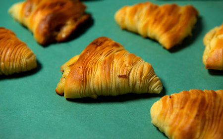 Close-up of Neapolitan Sfogliatelle, Traditional Italian puff Pastry Desserts stuffed with ricotta cheese on a Green background. Sweet Fragrant Background for advertising Cafes, Banks. Bannerの写真素材