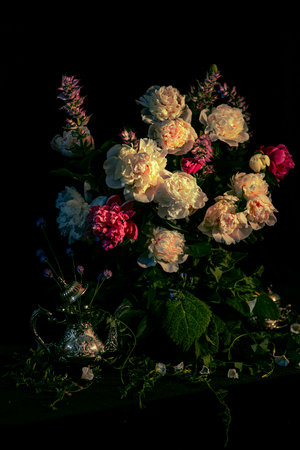 still-life.a bouquet of peonies and different flowers on a black background. Floral background.A pattern of fresh flowers.Floral postcard design with dark vintage effect.Template for the design.posterの写真素材