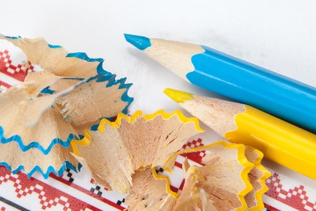 yellow and white pencil shavings on white paper background with a patternの写真素材