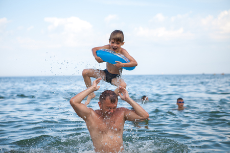 A happy family, father and son bathe in the water. Happy family on vacation, vacation. Have fun playing in the water.の写真素材