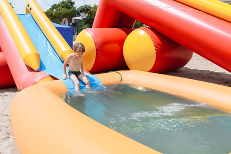 The boy is entertained outdoors, bathed in an inflatable pool.の写真素材