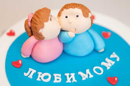 Sweet figures from the mastic of a couple in love on a cake. Figurines of the cupids on a cake, symbol of love and celebration.の写真素材