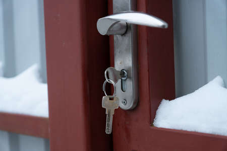 The key into the door with snowの写真素材