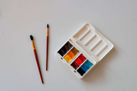 Watercolor paints and brushes on the tableの写真素材