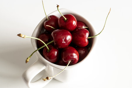 Cherries in a white bowl on the white background. Fruit wallpaperの写真素材