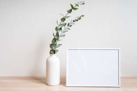 Minimalist home decor with empty frame mock-up on white wall backgroundの写真素材