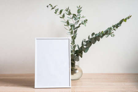 Minimalist home decor with empty frame mock-up on white wall background