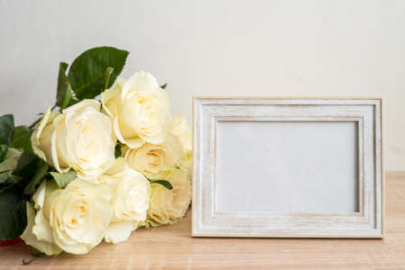 Portrait white frame mockup on table.Modern vase with rosesScandinavian interiorの写真素材
