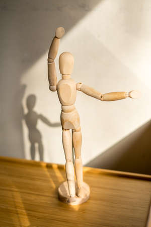 Wooden puppet stay under the table. Dancing pose Close-up view.