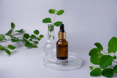 Bottle of essential oil with herb on grey background.の写真素材