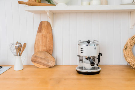 Modern coffee machine with cup on counter in kitchenの写真素材