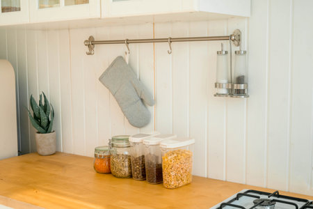 Various uncooked cereals, grains, beans and pasta for healthy cooking in glass jars on wooden table.の写真素材