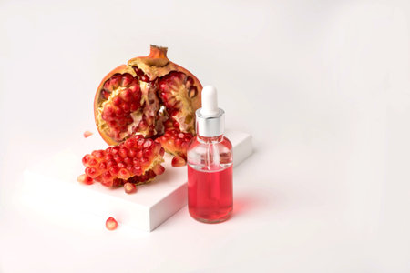 Composition with natural cosmetic oil and pomegranate on light background.の写真素材