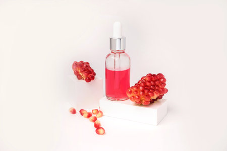 Composition with natural cosmetic oil and pomegranate on light background.の写真素材