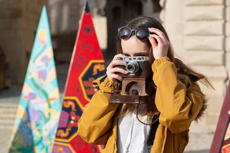 Photo of young tourist girl exploring streets of Baku. Moody photos of teenager girl visiting old city and taking photos of the city.の写真素材