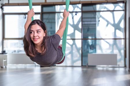 Photo of young woman practicing yoga indoor. Beautiful girl practice yoga in class. Yoga studio instructor. Blurred backgroundの写真素材