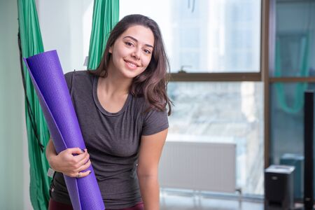 Portrait of young yoga woman yoga trainer indoor. Beautiful girl practice yoga in class. Yoga studio instructor. Blurred backgroundの写真素材