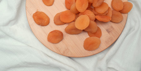 tasty dried apricots on the wooden board on white background.の写真素材