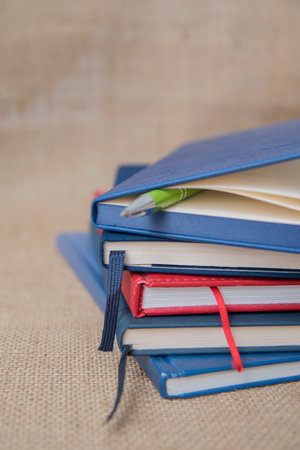 Close-up, notebook and textbooks on table, education concept. a stack of notebooks folded on the tableの写真素材