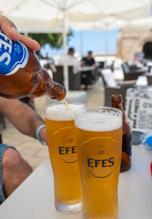 Kyrenia, Kyrenia, Northern Cyprus- June 1, 2024 : Man Pouring Cold Beer In A Glass in the hot summer dayのeditorial素材