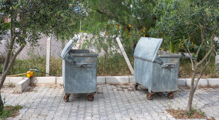 Garbage containers on an asphalt. Organization of municipal garbage collection services