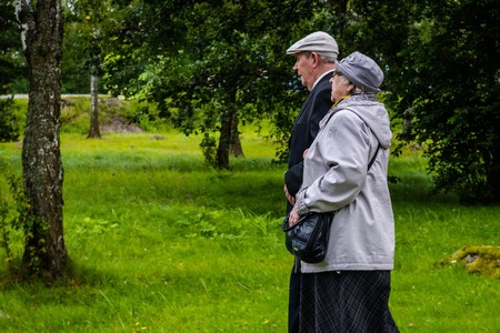 Russia, Priozersk, August 2016: An elderly couple together goes under the arm on the wooden walkwayのeditorial素材