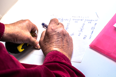 A person makes calculations on paperの写真素材