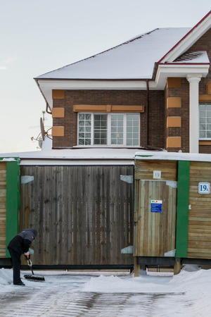 December 25, 2014 14:08 p.m. Russian Federation. St. Petersburg. Snow removal in front of a private houseのeditorial素材