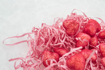 Pink hearts in a paper nest in the snowの写真素材