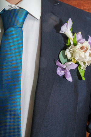 A small bouquet of flowers in the groom's suit