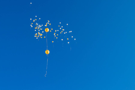 Balloons flying in the blue skyの写真素材