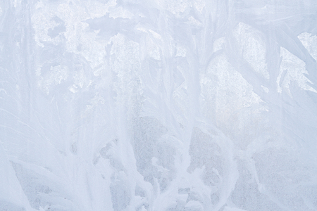 Winter frosty patterns on the frozen ice windowの写真素材