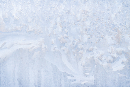 Winter frosty patterns on the frozen ice windowの写真素材