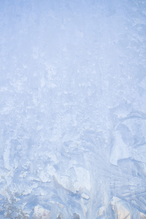 Winter frosty patterns on the frozen ice windowの写真素材