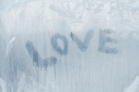 Love inscription on the frozen window in winter patterns in winterの写真素材