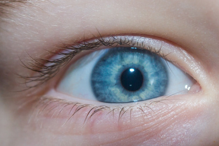 Baby blue beautiful, brooding eyes of a boyの写真素材