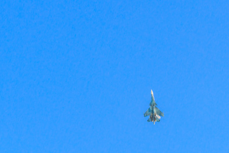 Military fighter jet far in blue sky