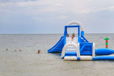 Evpatoria, Crimea, Russia, 17 June 2018. Inflatable entertainment attractions and slides on the shore at seaのeditorial素材