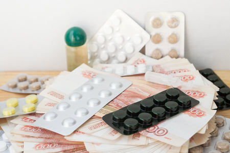 Pills and drugs with large Russian money lie on the tableの写真素材