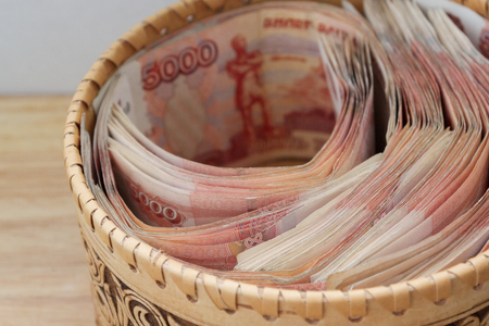 Big Russian money lies in a round wooden wicker boxの写真素材