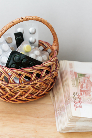Pills and medicines are in the basket next to the big Russian moneyの写真素材