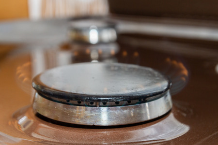 Gas stove with burning orange and blue fire on itの写真素材