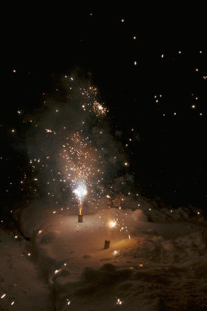 Bright colorful multicolored fireworks fountain in the snow at nightの写真素材