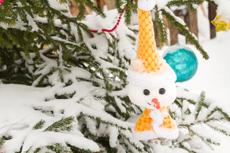 Christmas toy hanging on the tree outside in winterの写真素材