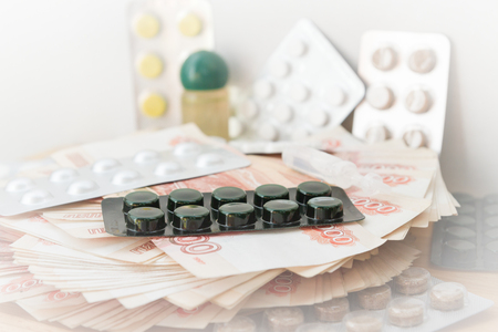 Pills and drugs with large Russian money lie on the tableの写真素材