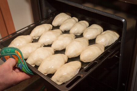 Freshly made pies lie on a baking sheet before cookingの写真素材